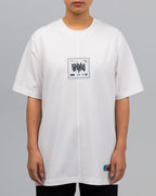 Frontalansicht einer Person im weißen T-Shirt. Das Shirt zeigt mittig auf der Brust ein quadratisches Patch mit der Aufschrift „AFTERLIFE“ und grafischen Elementen. Unten rechts ist das farbige Webetikett eingenäht.