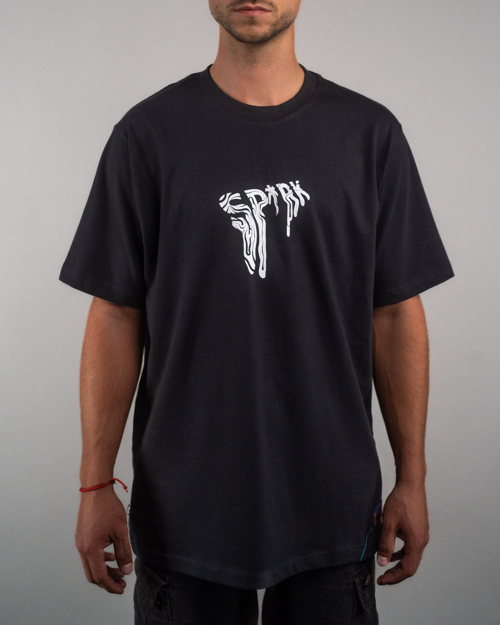 Frontalansicht eines schwarzen T-Shirts mit weißem, verzerrt-illustriertem „SPRK“-Schriftzug mittig auf der Brust. Der Schnitt ist locker und die Ärmel reichen knapp über die Ellenbogen.