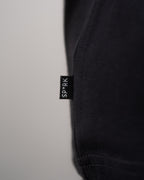 Brustausschnitt mit Nahansicht des weißen „SPRK“-Logos. Die Typografie ist in organisch fließender Liniengrafik gestaltet.