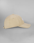 Rückansicht einer beigefarbenen Cap mit verstellbarem Riemen. Auf dem beigen Stoffband ist der weiße Schriftzug „SP*RK“ aufgedruckt. Der Riemen hat eine silberfarbene Metallschnalle, links ist ein blauer Stoffeinsatz sichtbar.