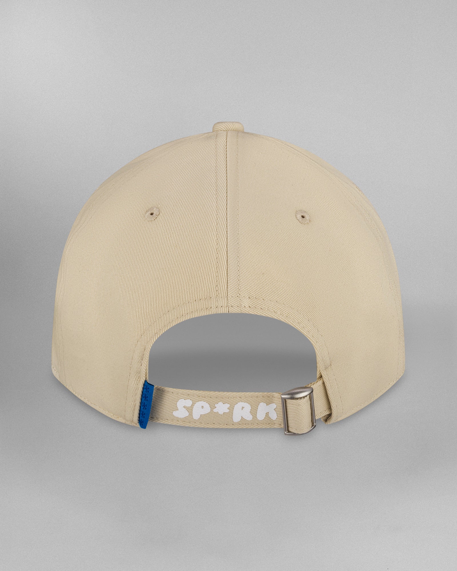 Beigefarbene Baseballcap in seitlich geneigter Frontansicht von rechts, mit dezent gebogenem Schirm und weißem Sticklogo in der Mitte. Nähte und Luftlöcher sind gleichmäßig verteilt.