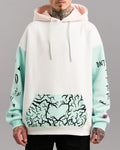 Hoodie in Weiß mit mintfarbenen Ärmeln und Kängurutasche. Die Tasche ist mit einem schwarzen, verästelten Herzmuster bedruckt. Die Kapuze ist innen rosa gefüttert. Auf dem linken Ärmel sind schwarze Illustrationen verteilt, auf dem rechten Ärmel beginnt eine Typografie.