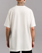 Rückansicht desselben weißen T-Shirts, schlicht ohne Print oder weitere Details, locker fallend mit geradem Saum.