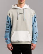 Frontalansicht des Hoodies mit Fokus auf die Vorderseite. Zu sehen sind die weiße Kängurutasche, hellblaue Ärmel mit schwarzem Druck und der zentrale schwarze „SPRK“-Schriftzug auf Brusthöhe.