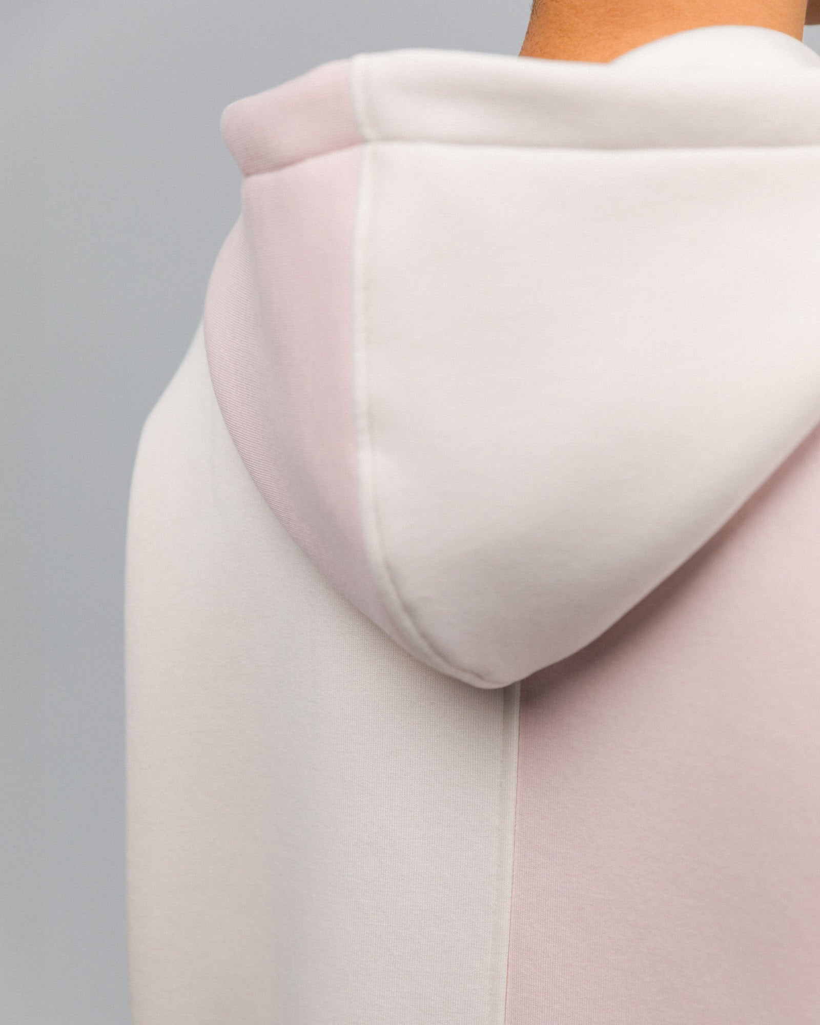 Die Kapuze ist aus zwei Stoffteilen zusammengesetzt – cremefarben links, rosa rechts – und mittig vernäht.