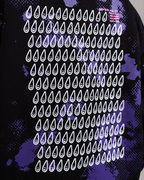 Großflächiger Print auf dem Rücken eines schwarzen Hoodies. Das Motiv besteht aus mehreren Reihen weißer Tropfen mit Gesichtern, auf violettem Punktmuster und Spritzflecken. Oben rechts befindet sich ein kleiner, orangefarbener Schriftzug mit kryptischen Zahlen- und Buchstabenkombinationen.