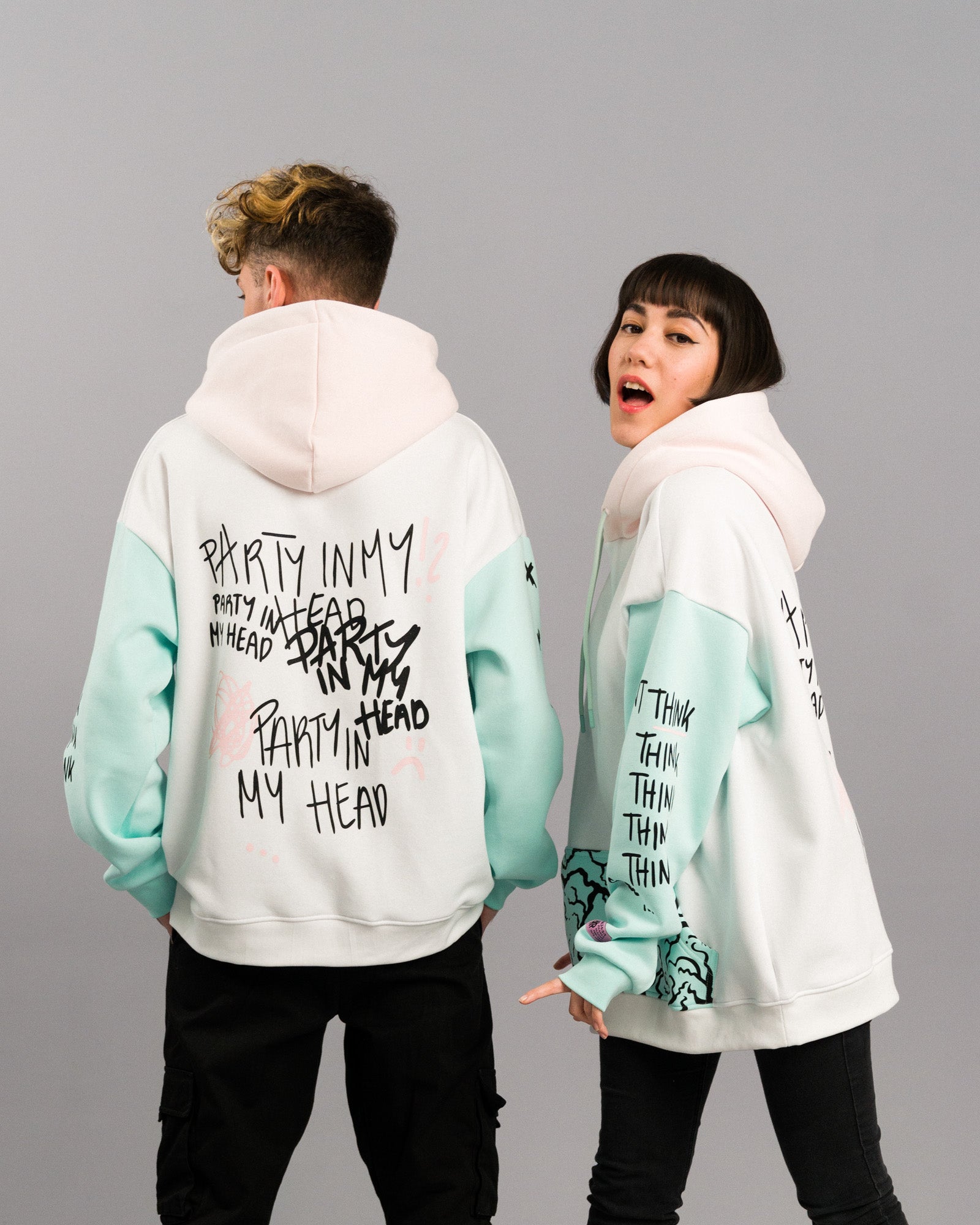 Zwei Personen in Rückansicht. Die Hoodies zeigen mehrfach den Schriftzug „PARTY IN MY HEAD“ auf dem Rücken und die Typografie „THINK“ auf den Ärmeln.