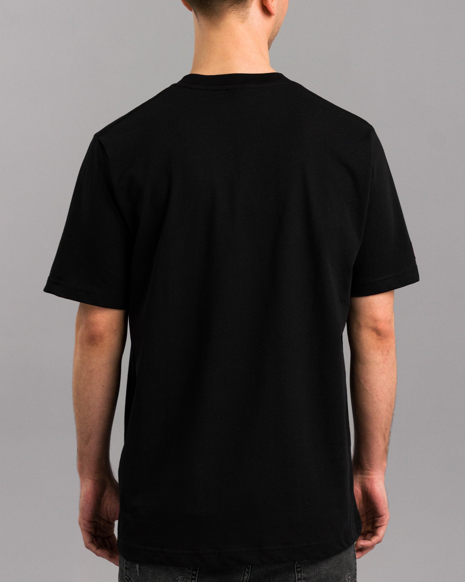 Rückansicht des schwarzen T-Shirts mit glattem Stoff ohne Print oder Applikationen.